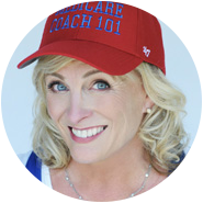 HeadshotTesmo2 Smiling woman with blonde hair wearing a red baseball cap that reads "MEDICARE COACH 101" in blue letters.